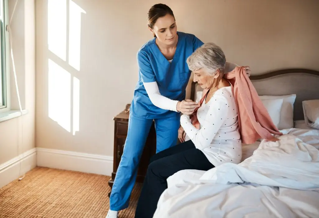 A nurse is helping an elderly woman to get ready for surgery.