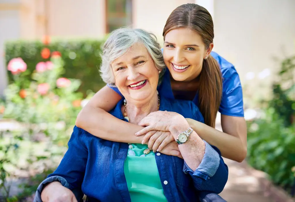 A woman and an older lady hugging each other.