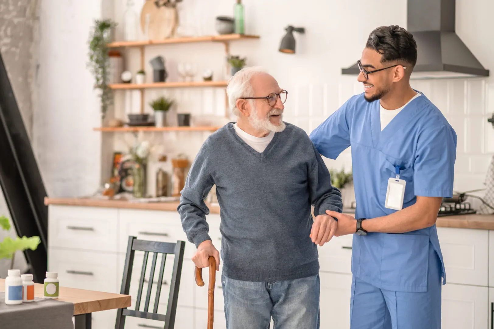 Medical worker helping his patient to move around the apartment Elderly man assisted by healthcare worker.